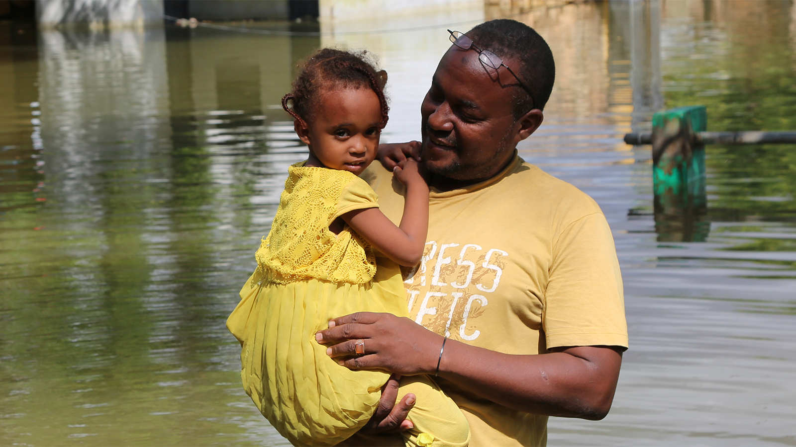 Aikuinen ja lapsi kuvattuna joen edessä