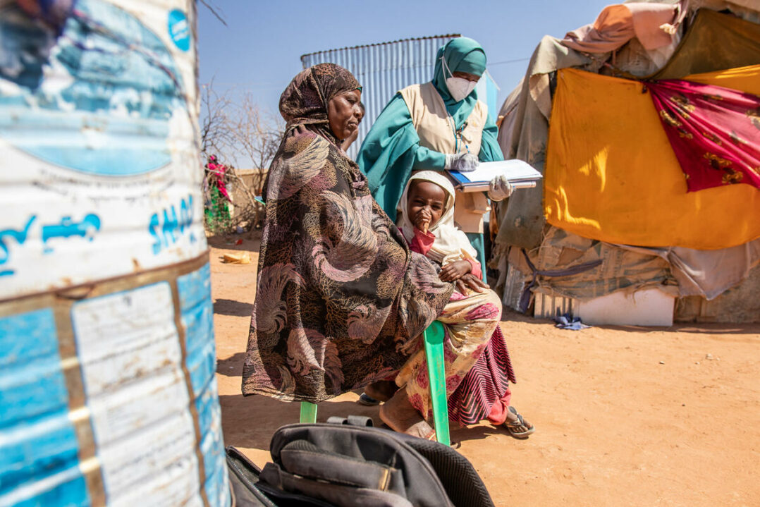 Tarinaan liittyvä kuva, jossa kolme ihmistä Somalian pakolaisleirillä.