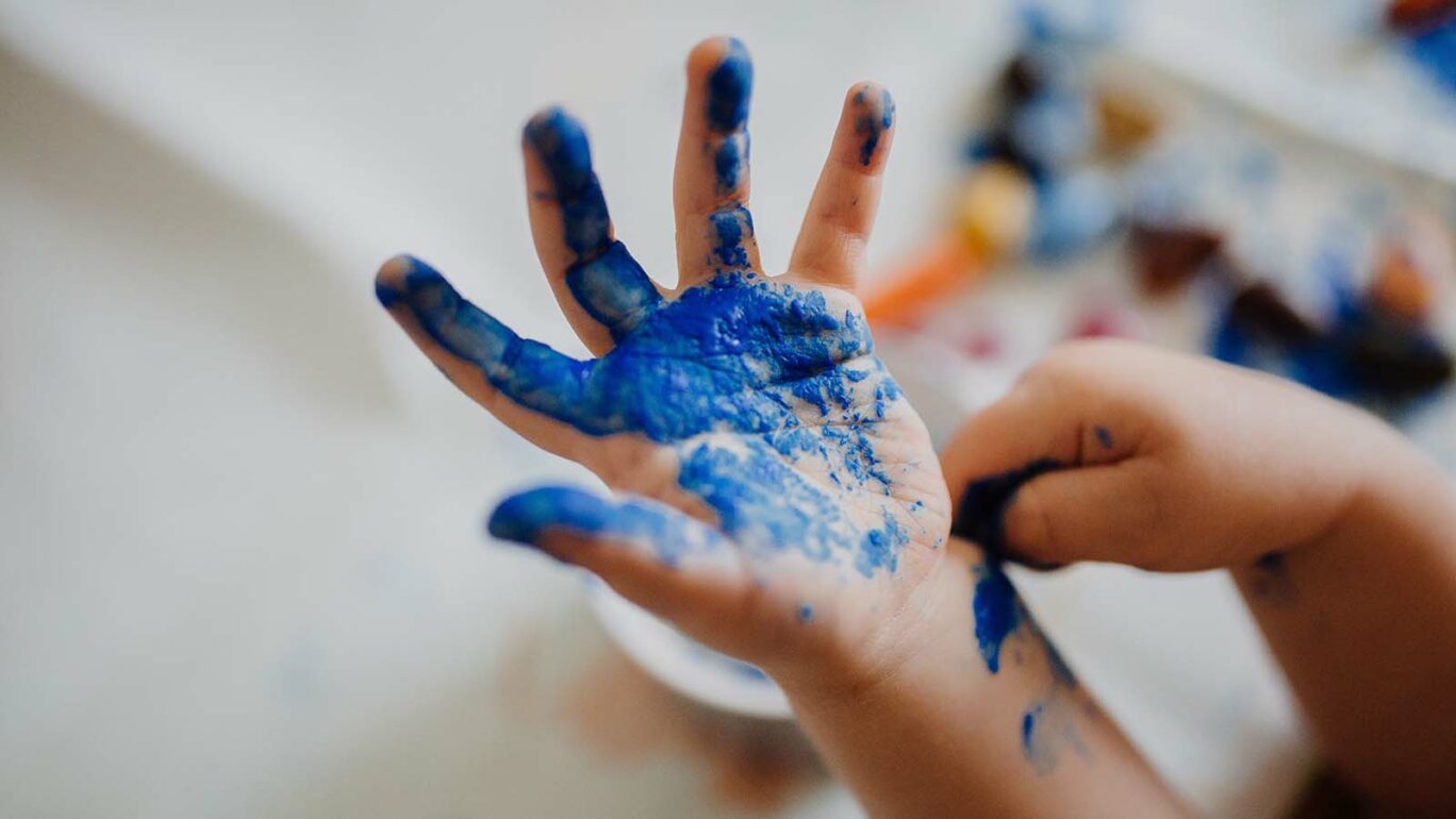 Lapsen kämmen sinisen maalin peitossa askartelujen jälkiltä